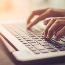 hands typing on a laptop